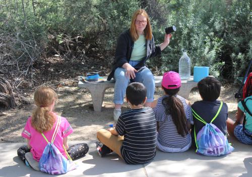 Photo of Arizona Project WET Tucson Water Educator Cora Thomas showing students water conservation technology at Sweetwater Wetlands